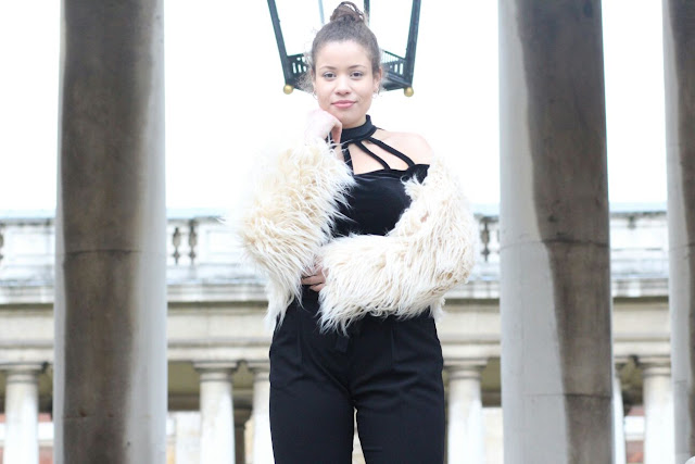 An image of Eboni posing in an Apricot Clothing long haired jacket, black Primark trousers and River Island top