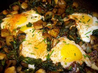 Skillet of potato and Swiss chard hash with eggs.