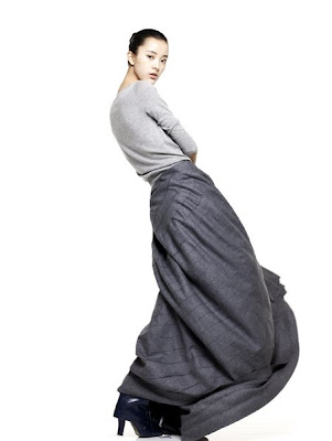  model Emma Pei in a billowing grey maxi skirt and long brown cardigan 