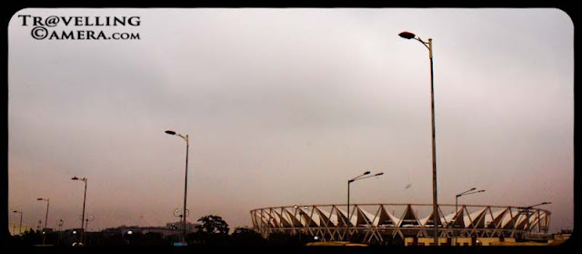 Dilli Bhraman in Monsoons  to check out the state of the city before CWG 2010 (Common Wealth Games) : Posted by VJ SHARMA @ www.travellingcamera.com : On a weekend, we were discussing overall progress of Delhi in last few months for Common Wealth Games.. and there were many debates happening on dinner table.. After some time we decided to have a round of Delhi next day to see what all is happening... Here are few photographs with some brief details about this journey which started from Noida...Yellow-&-Green Auto-Rikshaws are identity of Delhi and first attempt was to find an auto at reasonable cost for a day, which is very difficult task in Noida.. We hired one till Mayur Vihar Phase-1 to catch another friend there... After leaving Noida, we saw a fly-over where construction was going on and most of us thought that its impossible to complete it before CWG.. Lets see what happens...One of the Stadium near Safdarjung Tomb in Delhi...Its probably Jawaharlal Nehru Stadium... Just found another photograph of this stadium with nice details @ http://www.prlog.org/10899688-jawaharlal-nehru-stadium-features-tensile-membrane-fabric-roof-from-birdair-inc.html Green Delhi... I love all the drives around India Gate and CP.. These areas are comparatively green and clean... As you must have noticed that suddenly the main idea disappeared after some time.. I mean, after lunch no one was interested in exploring CWG progress... Here is a photograph of DND which connects Delhi with Noida... Its not allowed to stop the car on DND, so its clicked from moving car having tinted glasses :-) Another photograph of Wide roads of Delhi with sufficient greenery around...Some decorative stuff planted in the center of INA flyovers... Check out http://en.wikipedia.org/wiki/2010_Commonwealth_Games for more details about CWG 2010