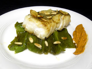 Bacalao confitado con pimientos verdes asados, romesco y piñones