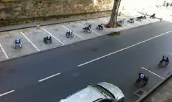 Line of empty wheelchairs parked in standard street side parking spaces in protest about handicapped parking