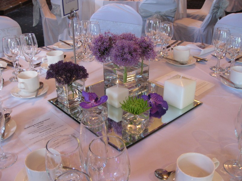 Each table centrepiece used the same glassware layout set with striking cube