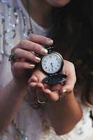 Profile of a young mom holding an alarm clock with outstretched hands