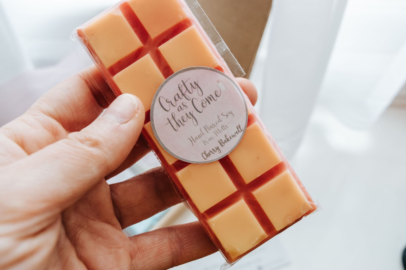 A red and orange Cherry Bakewell scented wax melt bar.