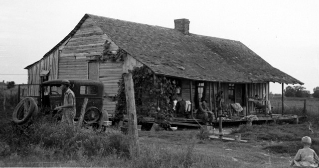 "Lawrence's home when we visited them, 1937." Tenant farm family on the house porch and in the surrounding yard.