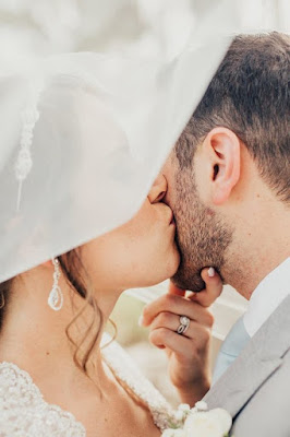 bride and groom kiss under veil