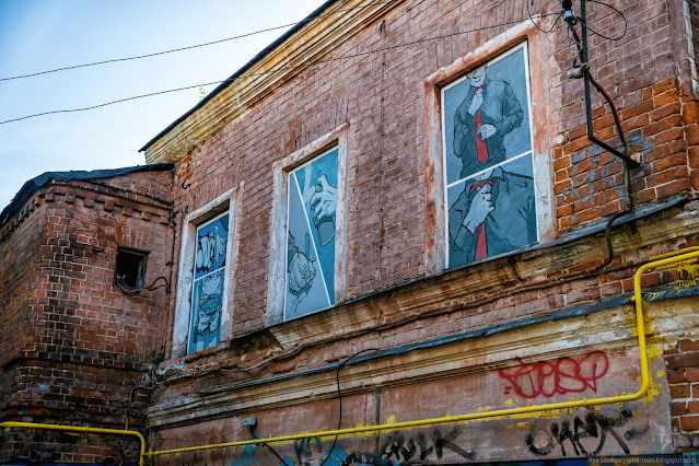 Три рисунка в заколоченных окнах кирпичного дома