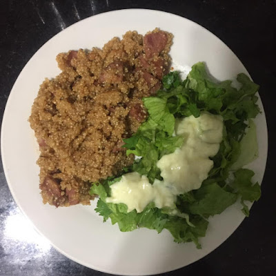 Quinoa com Linguiça Calabresa Refogada no prato na cor branca em cima de bancada de mármore na cor preta