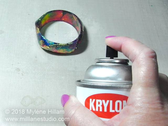 Spraying the alcohol ink painted bangle with clear acrylic spray.