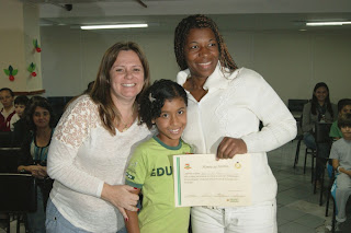 A Diretora do Departamento Pedagógico, Carla Rabello, entrega o certificado de participação