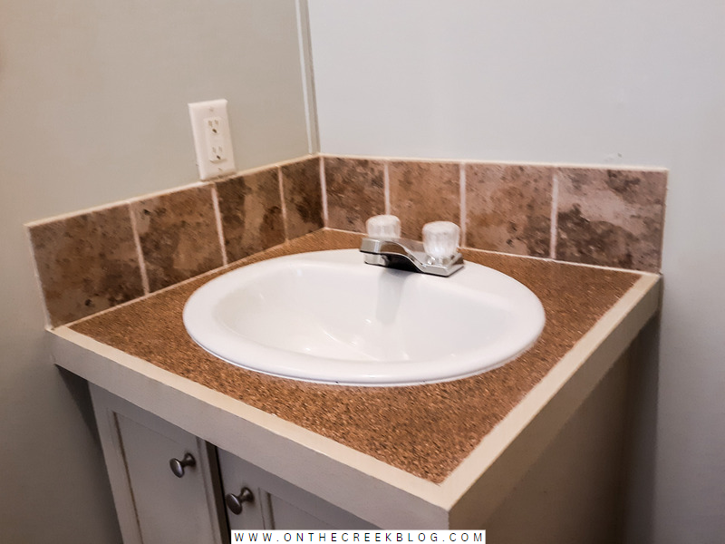 Textured spray paint countertop transformation in bathroom vanity, featuring a smooth finish achieved with triple-thick polyurethane. | on the creek blog // www.onthecreekblog.com