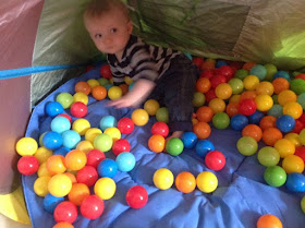 baby in tent with lots of different coloured balls