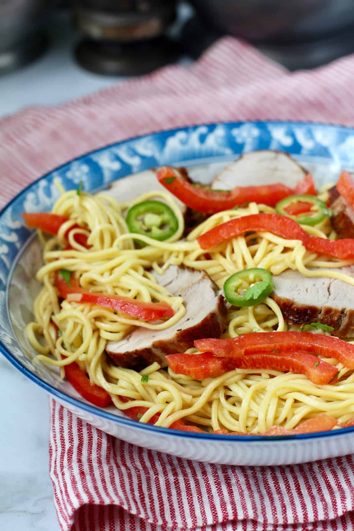 Chinese Egg Noodle Salad with Pork in a blue Asian-style bowl.