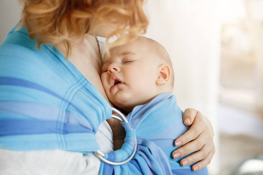 Mama cargando a su hijo con un cargador