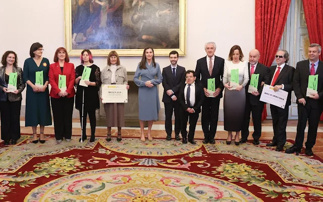 Queen Letizia wore a camel double-faced wool coat by Carolina Herrera, and wrap around side lacing dress by Adolfo Dominguez