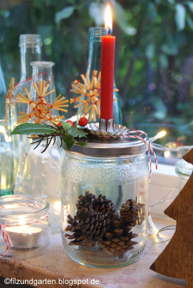 weihnachtlicher Kerzenhalter mit roter Kerze und Joghurtglas mit Zapfen