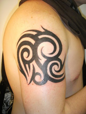 Man with drawing of tribal tattoo design on his shoulder, sleeve,