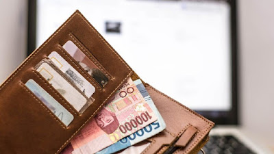 uang rupiah dan kartu kredit di dalam dompet
