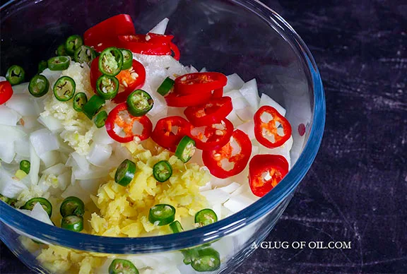 Onions garlic ginger and chillies in a glass bowl