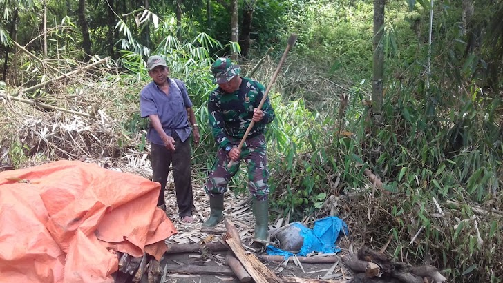 Anggota Satgas TMMD ke 104 Kodim 0417 /Kerinci Membantu Warga Memotong Kayu Bakar