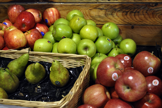 diferentes frutas expuestas, en primer plano peras y manzanas