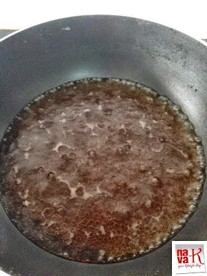 Palm sugar simmering in water inside a pan, creating a rich, caramel-like liquid