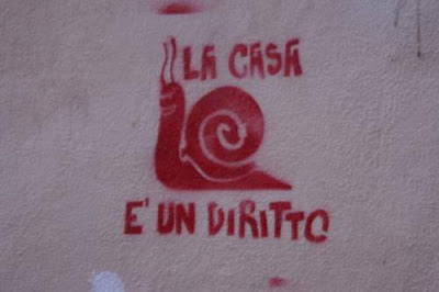 Graffiti image of a snail with a house on his back; a political appeal for housing rights from the old town centre of Genoa, Italy.