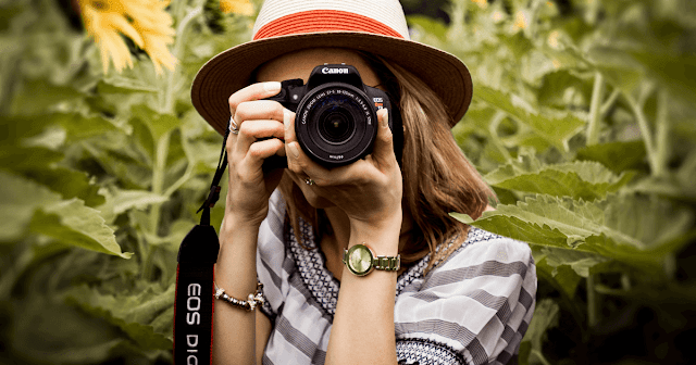 this is a picture of a woman using a DSLR camera