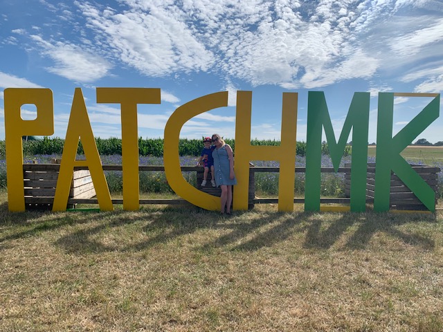 Mum and son standing next to giant letters that read PATCH MK