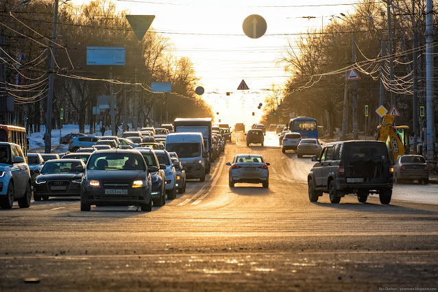 Городская улица с машинами залитая золотым солнечным светом