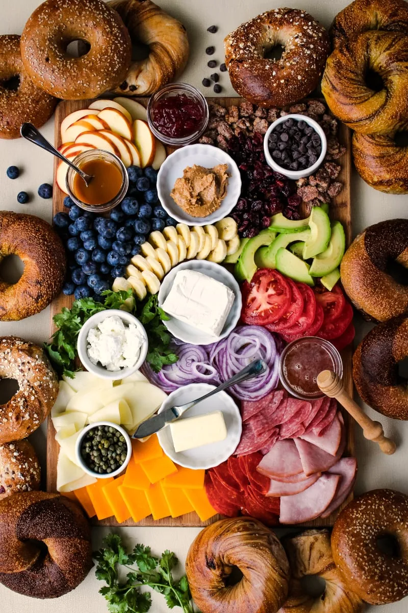 The Ultimate Bagel Bagel Brunch Board featuring New Yorker Bagels is loaded with bagel toppings galore!  A variety of spreads, fruits, vegetables, cheeses, meats, and a few unique toppings make this bagel board a showstopper. #breakfast #brunch #bagels #ad