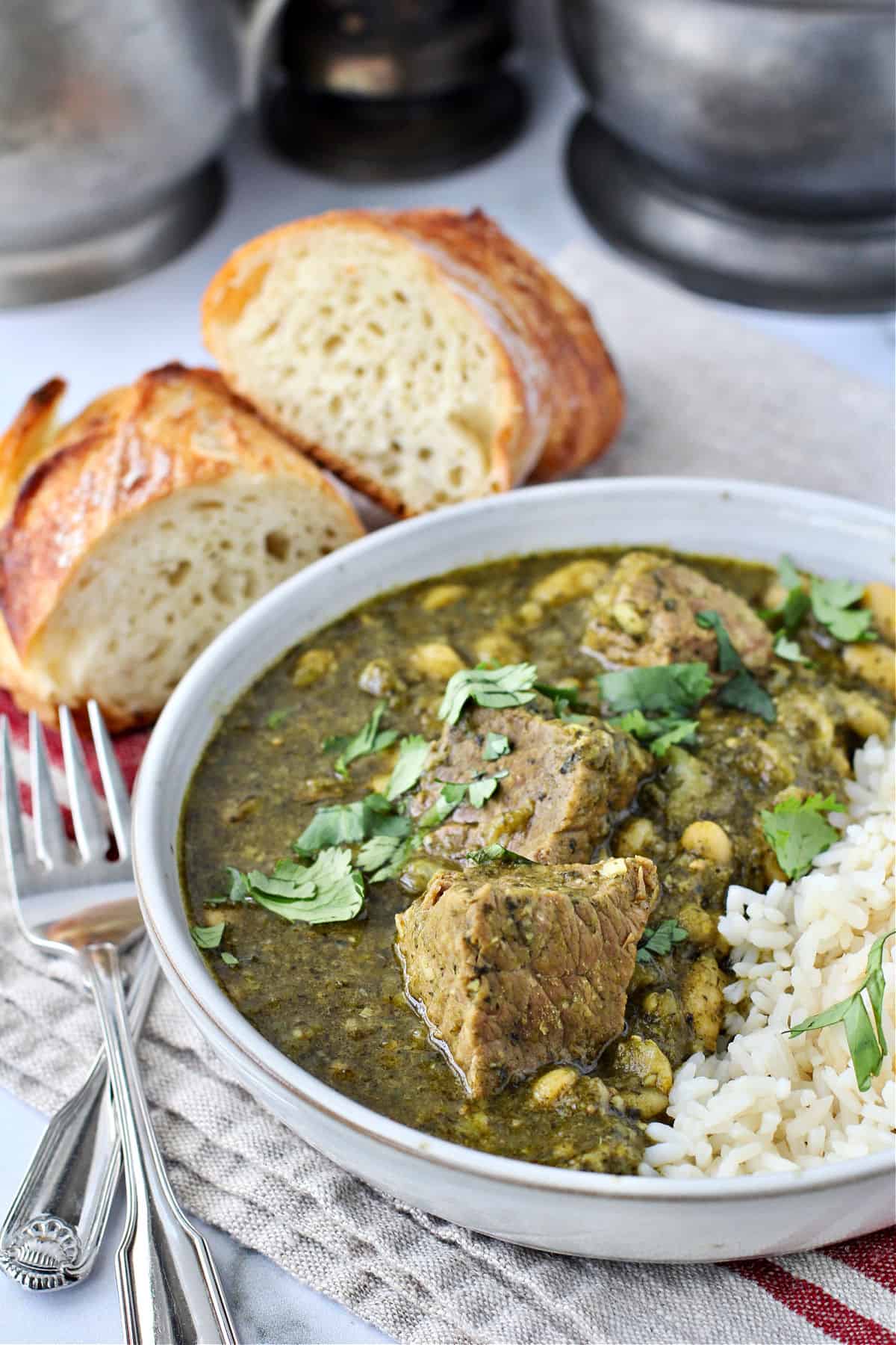 Bowl of libyan stew with bread pieces.