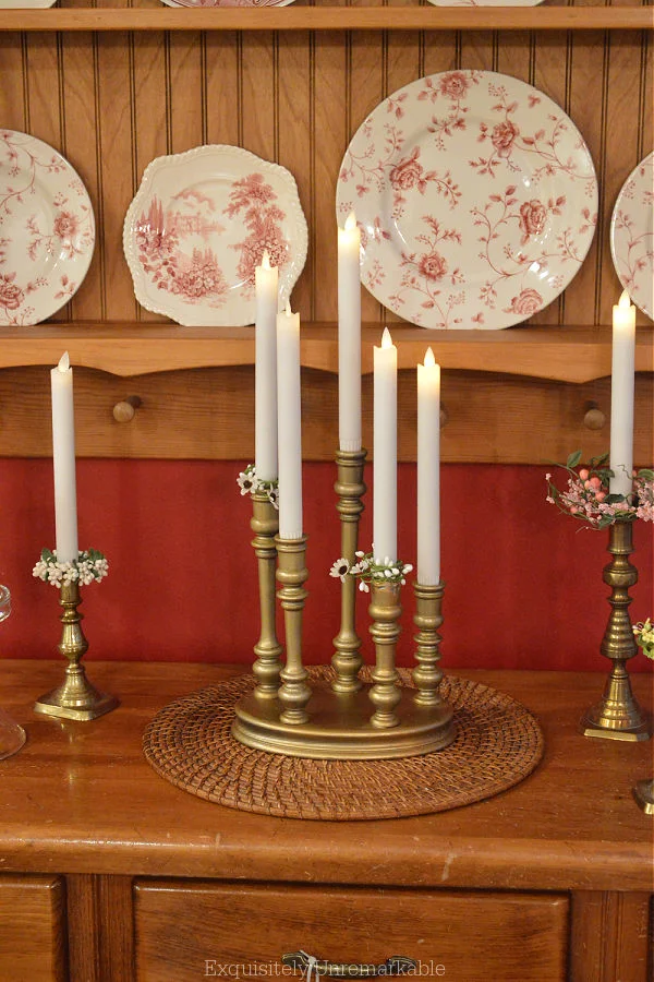 Brass Multi Candlestick Holder under a plate rack on a pine buffet