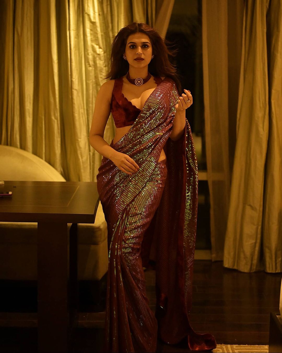 Shraddha Das in a sequin saree with maroon velvet blouse and choker necklace.