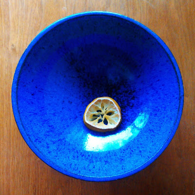 Image of a blue ceramic bowl with a slice of lemon inside