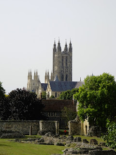 A photo showing the low ruined walls of St Augustine's Abbey in the foreground and the towering spires of Canterbury Cathedral in the background.  Photo by Kevin Nosferatu for the Skulferatu Project.