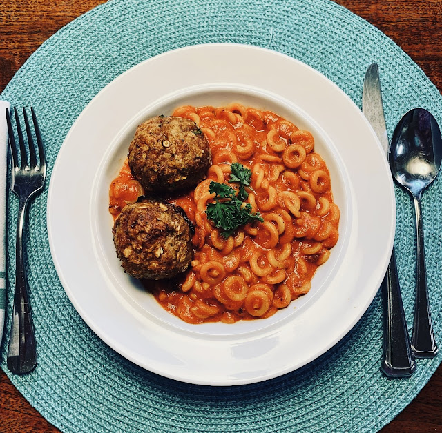 spaghettios with meatballs in a bowl on a placemat