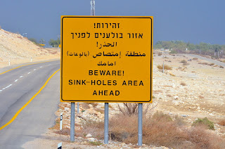 warning beware of sink holes sign dead sea israel