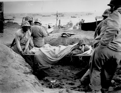 Carrying a Jap[anese] prisoner from stockade to be evacuated