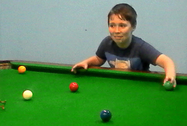 Boy holding a snooker ball. 