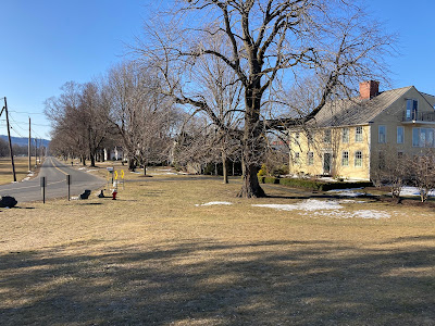 Looking south on West Street in Hadley Massachusetts a colonial home is set on the side of the broad street