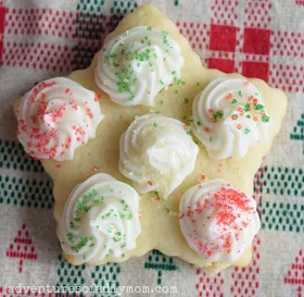 cut out cookie in a star shape with dots of frosting