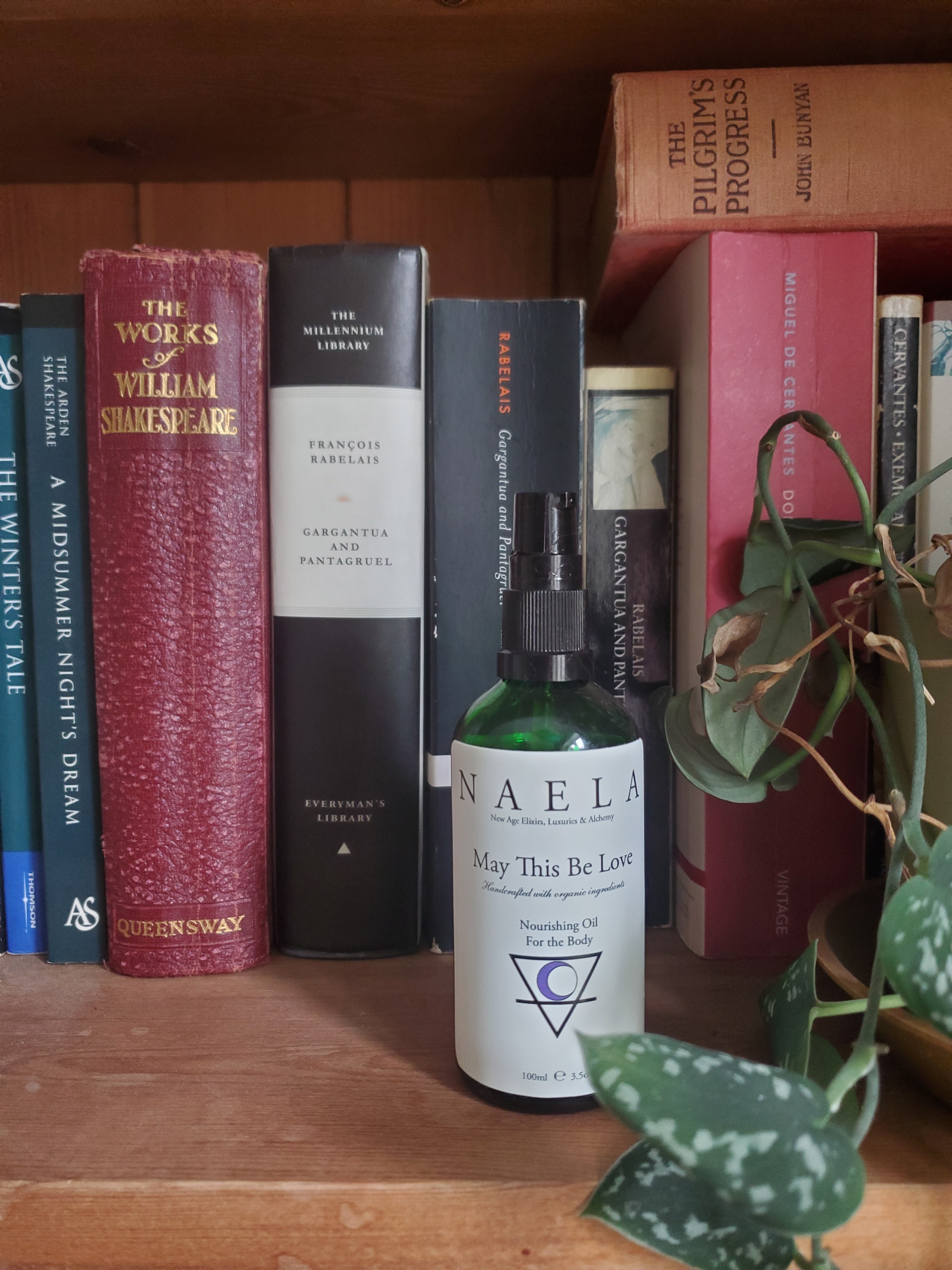 Naela body oil in front of a shelf of old books