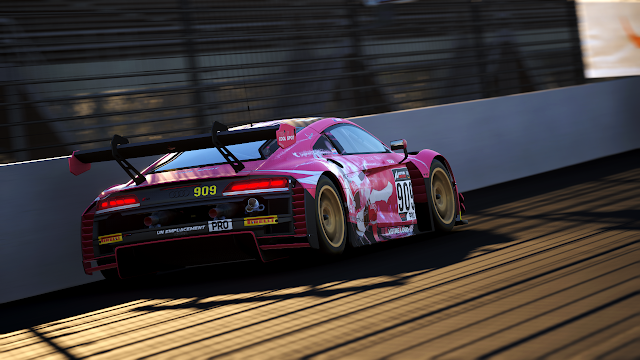 Picture from Assetto Corsa Competizione: an Audi R8 LMS evo II painted in the Queens' Design colours. It is pink with matte black and glossy white accents. On the sides is Victoire Laviolette, the team's mascot.