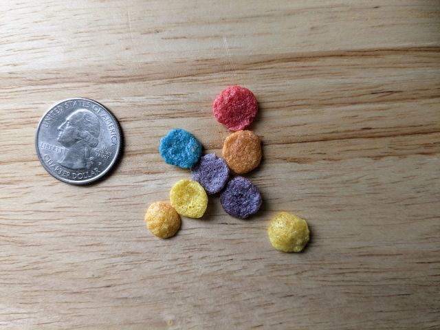Rainbow Krispies close-up with a quarter for size comparison.