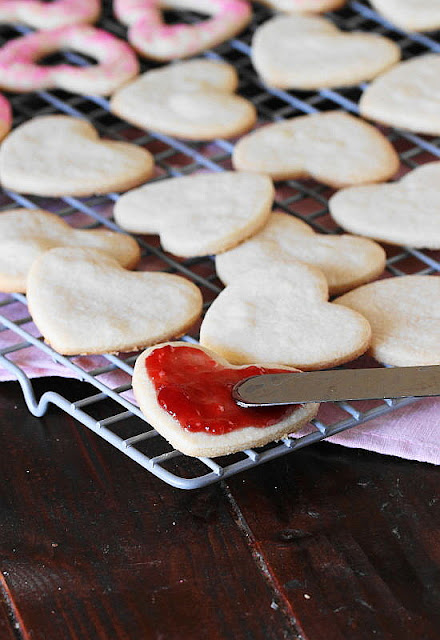 Spreading Raspberry Filling on Bottom Cookie for Valentine Raspberry Sandwich Cookies Image