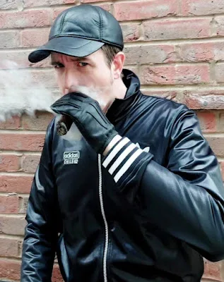 Taking a papa cigar wearing leather hat gloves and scally lad Adidas tracksuit