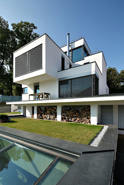 Home with White Concrete Wall and Black Blind Windows Made from Wooden Material