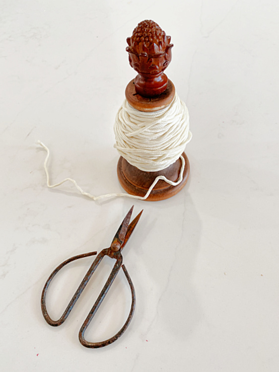 candlestick with string and scissors